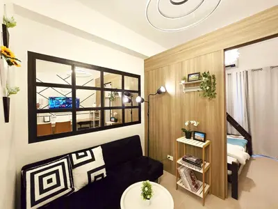 a small living room with a couch and a window at 1BR Condotel with Balcony at FAME Residences #FM40-1 in Manila