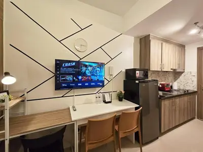 a kitchen with a table and a tv on the wall at 1BR Condotel with Balcony at FAME Residences #FM40-1 in Manila