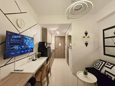 a living room with a large tv on the wall at 1BR Condotel with Balcony at FAME Residences #FM40-1 in Manila