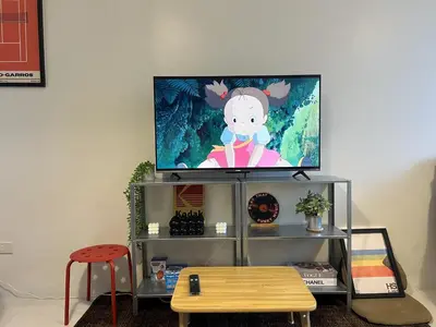 a flat screen tv sitting on top of a entertainment center at Cozy Nook l Accessible LRT QC l Wifi & Netflix in Manila