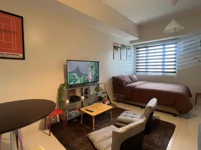 a small living room with a bed and a television at Cozy Nook l Accessible LRT QC l Wifi & Netflix in Manila