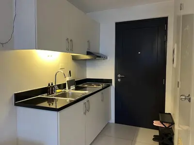 a kitchen with a sink and a black door at Cozy Nook l Accessible LRT QC l Wifi & Netflix in Manila