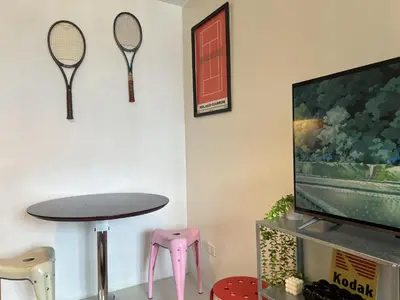 a room with a table and two tennis rackets on the wall at Cozy Nook l Accessible LRT QC l Wifi & Netflix in Manila
