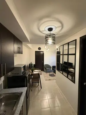 a kitchen with a sink and a table with chairs at NFr in Manila