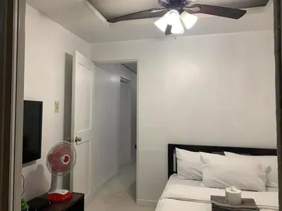 a bedroom with a ceiling fan and a bed at Birch Tower a9 front of Robinson PlaceRizal park in Manila