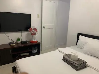 a bedroom with a bed with a television and a candle at Birch Tower a9 front of Robinson PlaceRizal park in Manila