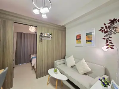 a living room with a couch and a table at 1BR Condotel with Balcony at FAME Residences #FM62-1 in Manila