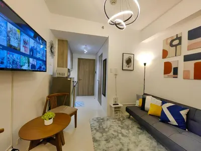 a living room with a couch and a flat screen tv at 1BR Condotel with Balcony at FAME Residences #FM01-1 in Manila