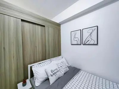 a bedroom with a bed and two pictures on the wall at 1BR Condotel with Balcony at FAME Residences #FM01-1 in Manila
