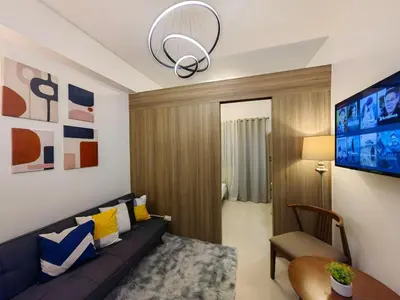a living room with a couch and a tv at 1BR Condotel with Balcony at FAME Residences #FM01-1 in Manila
