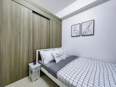 a small bedroom with a bed and a wall at 1BR Condotel with Balcony at FAME Residences #FM01-1 in Manila
