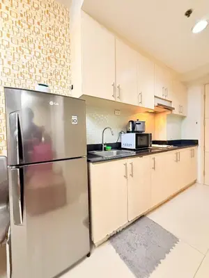 a kitchen with a stainless steel refrigerator and cabinets at Sea Residences Manila Condotel by Paul in Manila
