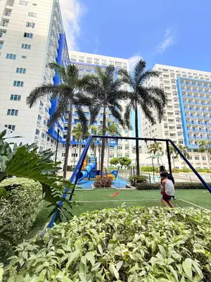 a person playing on a swing set in a park at Sea Residences Manila Condotel by Paul in Manila