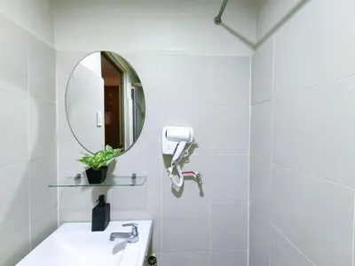 a white bathroom with a sink and a mirror at 1BR Condotel with Balcony at FAME Residences #FM02-1 in Manila