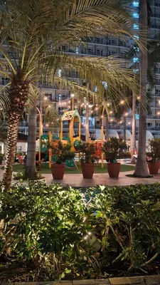 a courtyard with palm trees and plants in a building at Shell Residences MOA - JOSH in Manila