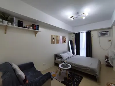 a living room with a bed and a couch at Pet Friendly Staycation at Pasig City in Manila