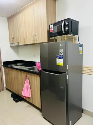 a kitchen with a stainless steel refrigerator and a microwave at City Solace in Manila