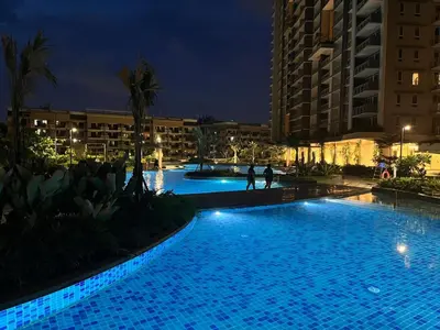 a swimming pool at night with people walking around it at 86 sqm, 3BR condo, Free Prking, WiFi, ntflx in Manila