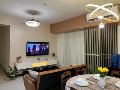 a living room with a television on a wall at 86 sqm, 3BR condo, Free Prking, WiFi, ntflx in Manila