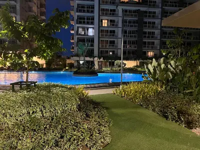 a swimming pool at night in a city at 86 sqm, 3BR condo, Free Prking, WiFi, ntflx in Manila