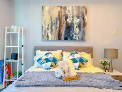 a bedroom with a bed with a painting on the wall at Azure Staycation in Manila