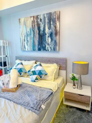 a bedroom with a bed with a painting on the wall at Azure Staycation in Manila
