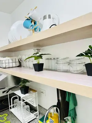 a shelf with pots and pans and plants on it at Affordable Condo Near SM Southmall in Manila