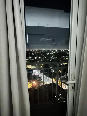 a view of a city at night from a window at Affordable Condo Near SM Southmall in Manila