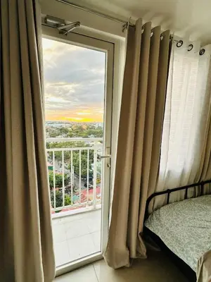 a bedroom with a window with a view of the city at Affordable Condo Near SM Southmall in Manila