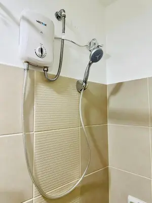 a shower with a hose attached to a wall at Affordable Condo Near SM Southmall in Manila