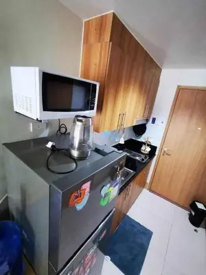 a kitchen with a microwave on top of a refrigerator at Mall of Asia condotel residence shore 3 in Manila