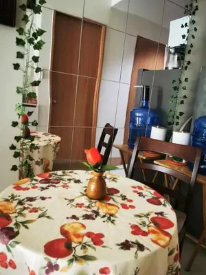 a table with a floral table cloth with a vase on it at Mall of Asia condotel residence shore 3 in Manila