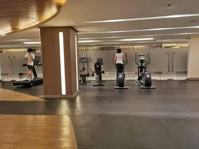 a gym with two women walking around in a gym at Mall of Asia condotel residence shore 3 in Manila