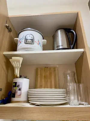 a cupboard with dishes and a tea pot and plates at Positano 933 in Manila