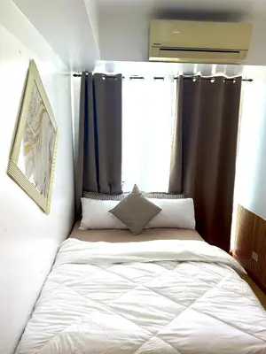 a bedroom with a large bed with black curtains at Positano 933 in Manila