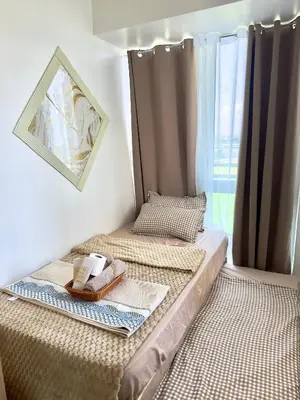 a bedroom with two beds and a tray of food at Positano 933 in Manila