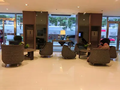a person sitting at a table in a lobby at Shore Residences - Cozy 1BR Apartment near MOA in Manila