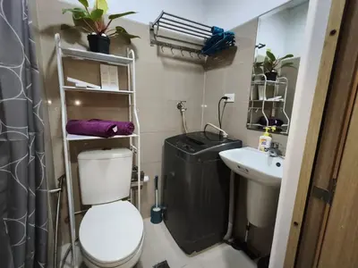 a small bathroom with a toilet and a sink at Shore Residences - Cozy 1BR Apartment near MOA in Manila
