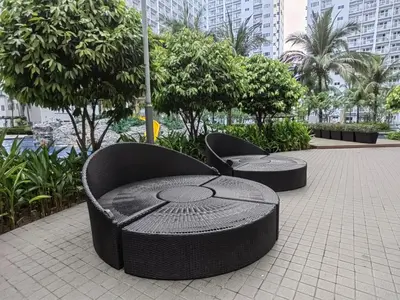 two chairs sitting on a sidewalk with trees and buildings at Shore Residences - Cozy 1BR Apartment near MOA in Manila