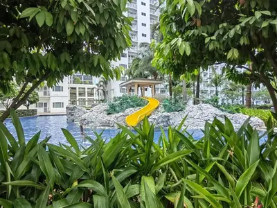 a yellow slide in the middle of a river with buildings at Shore Residences - Cozy 1BR Apartment near MOA in Manila
