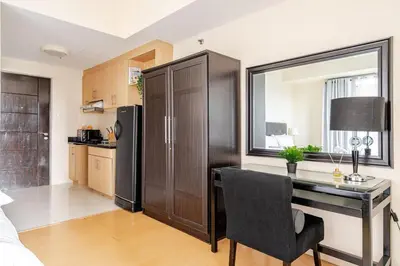 a kitchen with a desk and a refrigerator in a room at Avant at the Fort King bed Central 5mins to Highstreet BGC in Manila