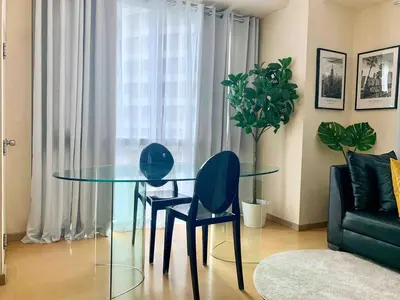 a dining room with a glass table and two chairs at Avant at the Fort King bed Central 5mins to Highstreet BGC in Manila