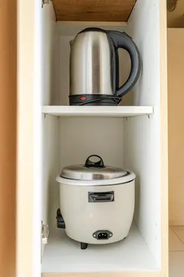 a tea kettle sitting on a shelf in a cupboard at Avant at the Fort King bed Central 5mins to Highstreet BGC in Manila