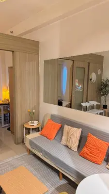 a living room with a couch with orange pillows at Shore Residences Haru Cozy pad Near Mall of Asia and Airport in Manila