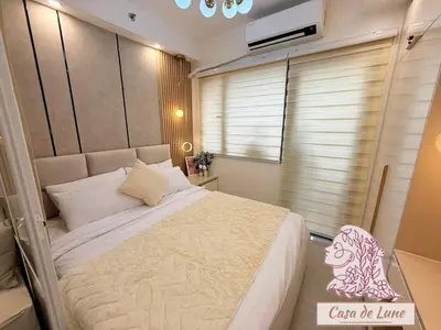 a bedroom with a large bed and a window at Mall of Asia Casa de Lune at Shore 2 in Manila