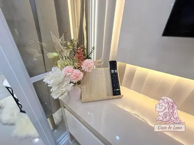 a vase of flowers on a table next to a window at Mall of Asia Casa de Lune at Shore 2 in Manila
