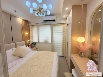 a bedroom with a large bed and a chandelier at Mall of Asia Casa de Lune at Shore 2 in Manila