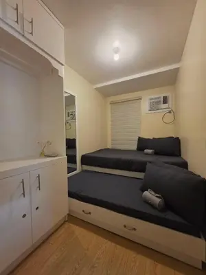 a small bedroom with two beds and a closet at Urban Oasis for 7 with 200 mbps & Netflix in Manila