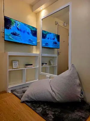a bedroom with a mirror and two televisions on the wall at Urban Oasis for 7 with 200 mbps & Netflix in Manila