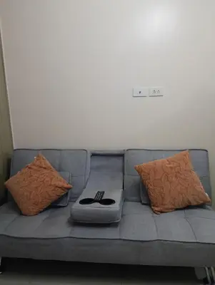 a gray couch with pillows and a controller on it at Shore moa view in Manila